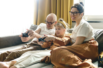 Happy family is playing video game console at home