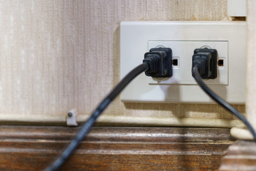 Two electrical plugs are plugged into the wall outlet