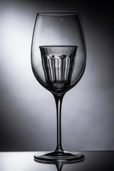empty shot glass in wine glass on dark background