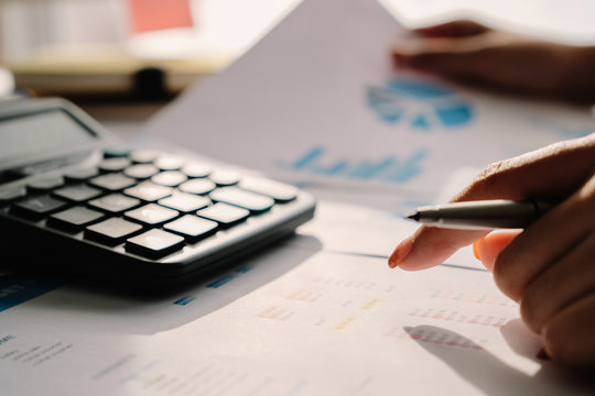 Business man analysis financial report on working desk and couting with calculator at home