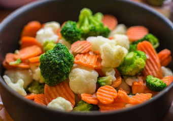 Pot full of cutted vegetables broccoli, carrot and cauliflowers