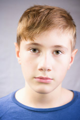 young boy looking at camera. neutral tranquil emotional portrait of a 10-12 years boy