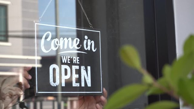 Text on vintage black sign "Come in we're open" in cafe.