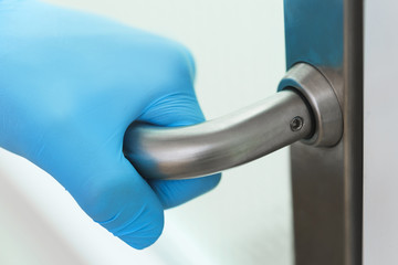 Doctor's hand on the metal door handle