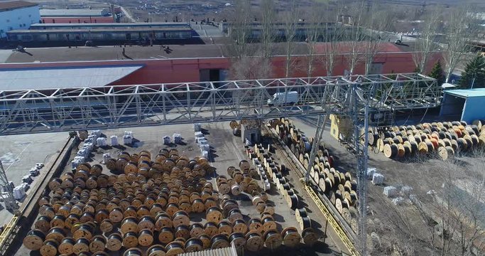 Cable production factory, top view, warehouse of reels with cables near the factory. Large plant top view