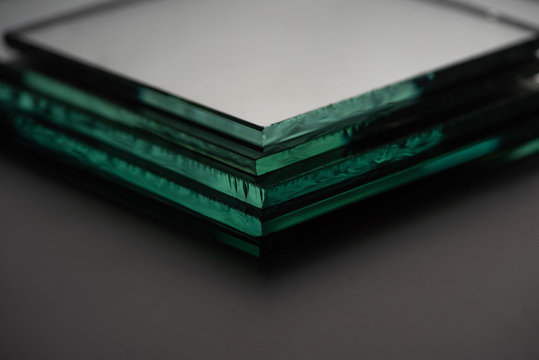 close up view of mirror pieces in stack on dark background