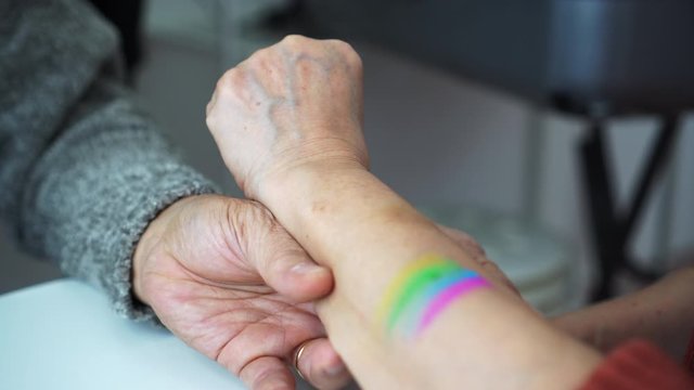 Asian mother and father paint pride flag to support LGBTQ family member unconditional love of parenthood