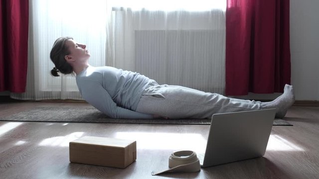 Caucasian woman on a yoga mat doing the fish pose