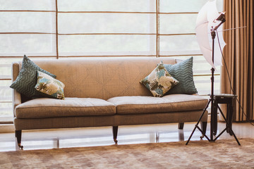 Interior with modern furniture, bright spring studio with a beautiful beige sofa and colored decorative pillows. Beige studio interior with professional lighting for photography.