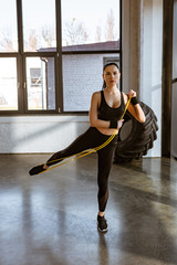 Obraz premium Sportswoman working out with resistance band in gym