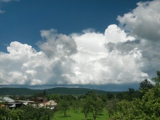 Fototapeta na wymiar stormy clouds over green forest in summer season