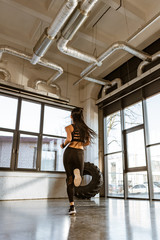 Back view of brunette sportswoman running on spot in gym