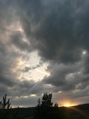 Obraz premium stormy clouds over green forest in summer season