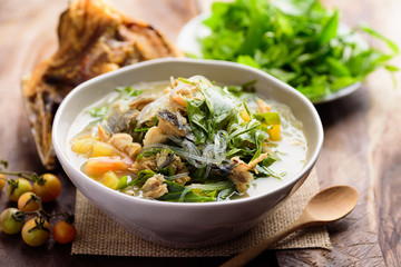 Northern Thai food (Kang Pak Wan Pa), Spicy local Thai vegetable soup with dry fish and glass noodles in a bowl on wooden background, Local Thai food