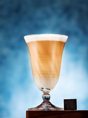 Cappuccino coffee in a glass goblet and chocolate