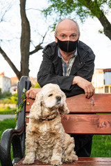 Senior man in protective mask with american cocker spanie
