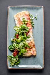 Grilled salmon with salad tomato microgreen vegetables dish top view black background
