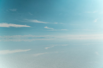 Blue Sky Clouds Mirror Reflection. Cloud Sky reflect on water surface of Bolivia's Salt Flats. Empty space in landscape. Holiday, vacation, freedom scene with horizon. Salar de Uyuni salt flat