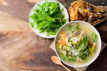 Northern Thai food (Kang Pak Wan Pa), Spicy local Thai vegetable soup with dry fish and glass noodles in a bowl on wooden background, Local Thai food, Top view