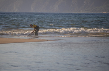 Fisherman casting the net into the sea.