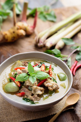 Thai food, Green curry with pork (Kang Keaw Wan) in a bowl with ingredients on wooden background