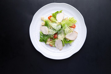 salad with chicken in a plate on a dark background
