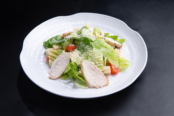 salad with chicken in a plate on a dark background