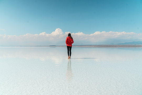 Travel. Woman. Salt Flats Uyuni Bolivia. Tourist girl on beautiful mirror reflection on blue sky and cloud. DRONE Shot in Salar de Uyuni salt flat. Holiday, love, adventure vacation honeymoon travel