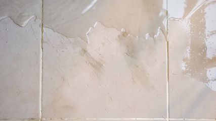 transparent water spreads across floor white tile top view