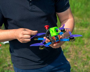 man repairs and adjusts a racing drone before flying