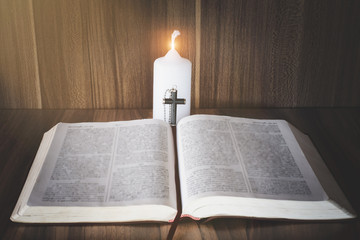 Crucifix and bible While there are candles that illuminate the Christian religious concepts Bible study.