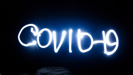 lettering with covid - 19 light at night at high exposure  (freezelight)