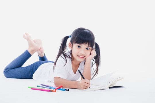 A young asian girl drawing a picture. On white