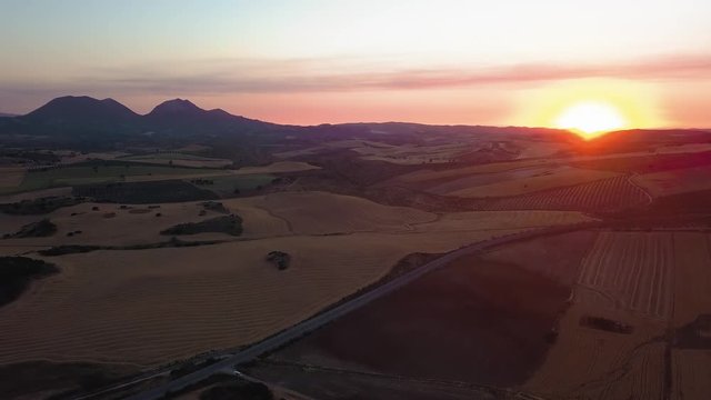 Drone point of road on mountain by river against cloudy sky during sunset