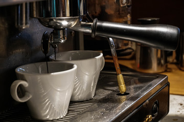 Two cups of coffee being prepared in a cafe shop. Professional coffee machine. 