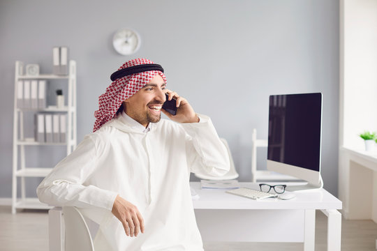 Arab Man Talking On A Cell Phone In The Office.