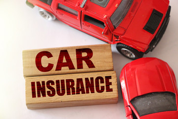 Car insurance words on wooden blocks and two red cars in road accident on white background....