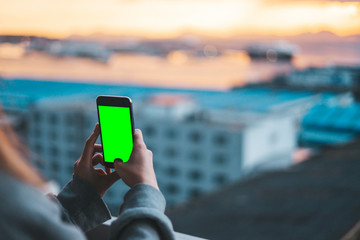 Woman taking photos with a smartphone on green screen