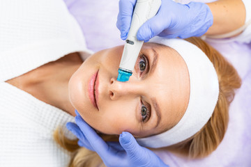 Serene female patient during the microdermabrasion treatment
