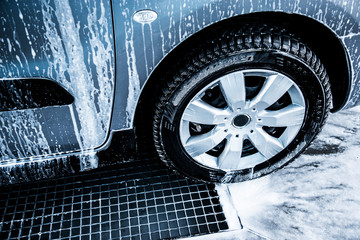 Fototapeta na wymiar Washing car with soap. Close up clean car concept at car wash.