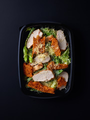 Caesar salad in plastic box for take away, from above