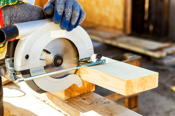 Manual circular circular saw on wood metabo. A man at a construction site saws a wooden Board bar close-up. The concept of working with wood on a sawmill. Woodworking equipment.
