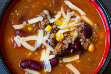 chilli con carne soup bowl with beans, corn, meat and cheese close up. horizontal, top view