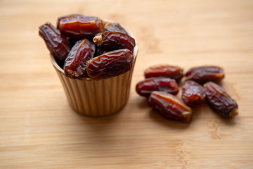 dates in a bowl on a wooden table . Top view.