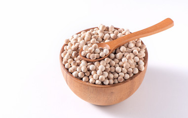 Dry raw brown tapioca pearls in a wooden bowl with spoon isolated on white background, close up, ingredient of making bubble boba milk tea.