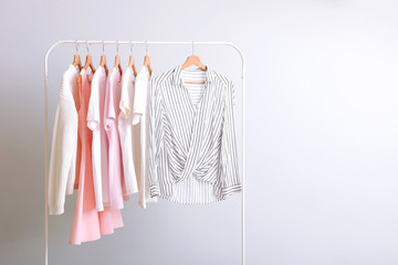 fashion clothes on a rack in a light background indoors. place for text