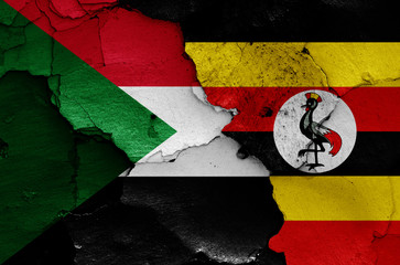 flags of Sudan and Uganda painted on cracked wall