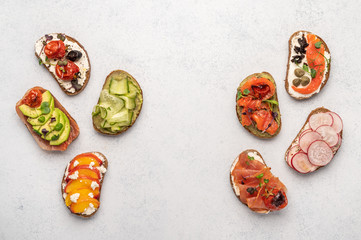 Homemade sandwiches with bread and various ingredients and spices on a light background. Healthy delicious food for breakfast and lunch