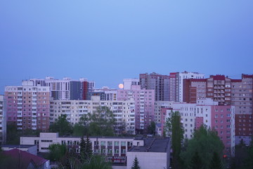 Fototapeta premium View of the huge moon, city, courtyard, street. Full moon. View from the window.