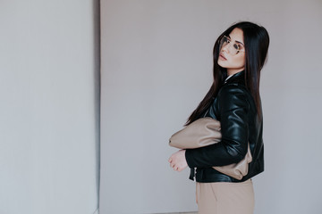 Beautiful fashionable eastern brunette woman in black leather jacket